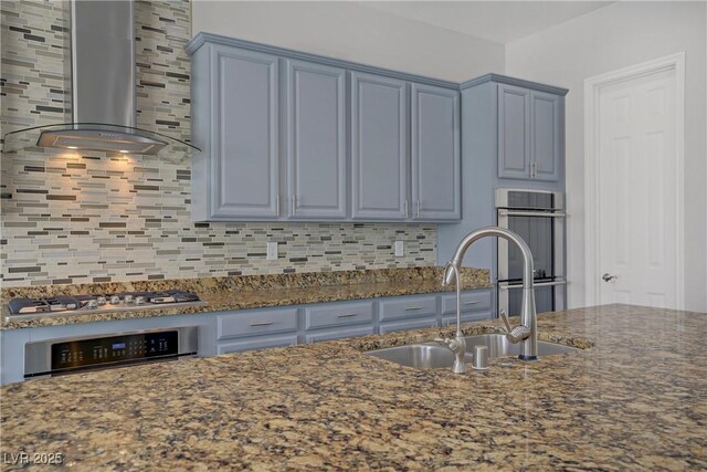 9779 Mosaic Canyon Ct, Las Vegas, NV 89149 - kitchen featuring wall chimney range hood, a sink, stainless steel appliances, decorative backsplash, and dark stone countertops