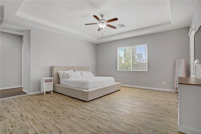 9779 Mosaic Canyon Ct, Las Vegas, NV 89149 - bedroom with a tray ceiling, light wood-style floors, baseboards, and a ceiling fan