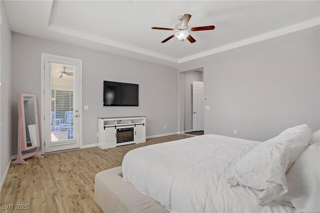 9779 Mosaic Canyon Ct, Las Vegas, NV 89149 - bedroom featuring a tray ceiling, access to outside, wood finished floors, and baseboards