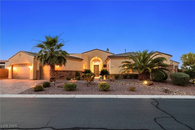 7504 Frittata Ave, Las Vegas, NV 89113 - mediterranean / spanish-style house with a garage, driveway, stucco siding, and stone siding