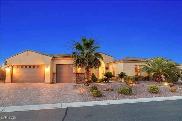 7504 Frittata Ave, Las Vegas, NV 89113 - mediterranean / spanish home featuring a garage, roof mounted solar panels, decorative driveway, and stucco siding