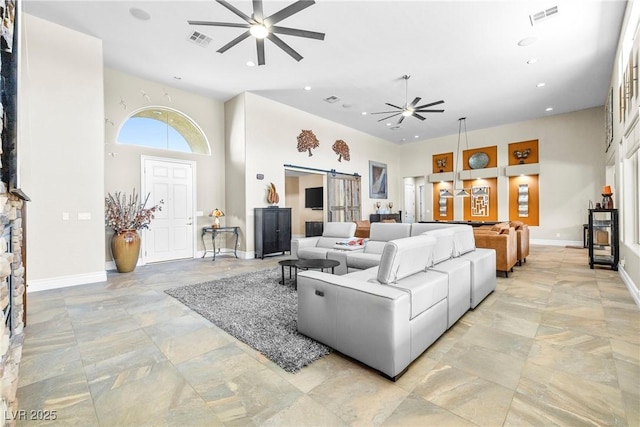 7504 Frittata Ave, Las Vegas, NV 89113 - living room with ceiling fan, a barn door, a towering ceiling, baseboards, and recessed lighting