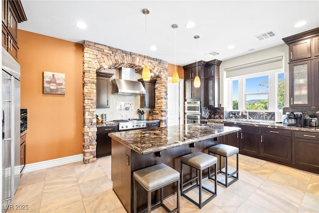 7504 Frittata Ave, Las Vegas, NV 89113 - kitchen featuring wall chimney exhaust hood, backsplash, stainless steel appliances, and recessed lighting