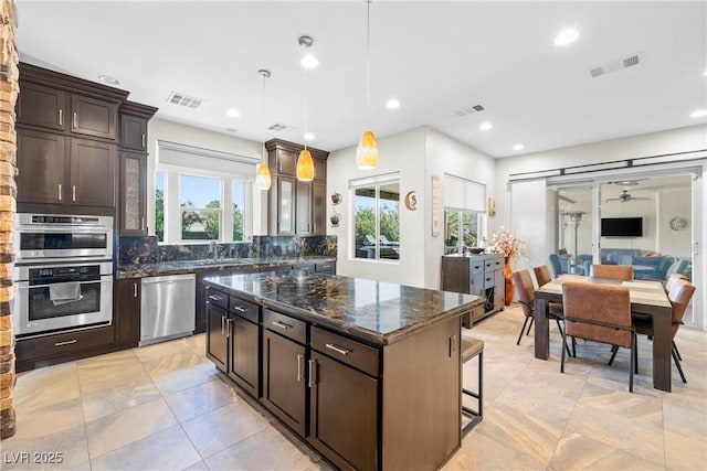 7504 Frittata Ave, Las Vegas, NV 89113 - kitchen featuring appliances with stainless steel finishes, tasteful backsplash, a sink, dark stone countertops, and recessed lighting