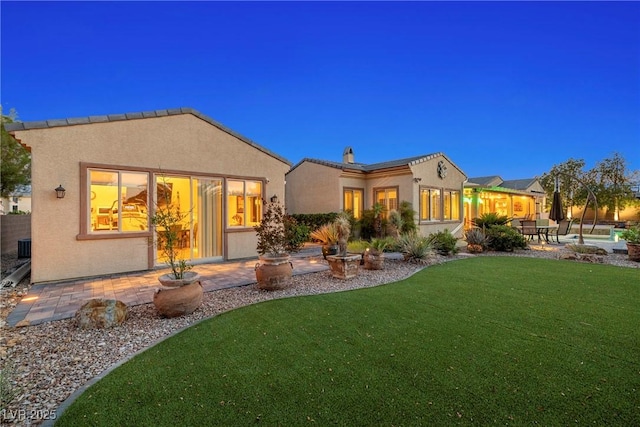 7504 Frittata Ave, Las Vegas, NV 89113 - back of property featuring stucco siding, a lawn, and a patio area