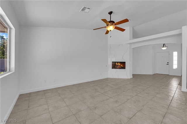 5437 Escallonia St, Las Vegas, NV 89149 - unfurnished living room featuring healthy amount of natural light, a ceiling fan, a premium fireplace, light tile patterned flooring, and high vaulted ceiling
