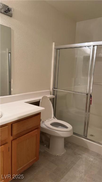 4555 E Sahara Ave Unit 122, Las Vegas, NV 89104 - bathroom with vanity, a stall shower, and toilet