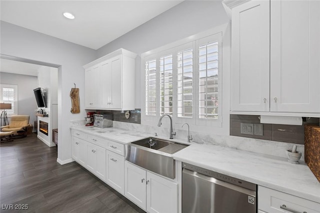 6173 Sabine Ranch Rd, Las Vegas, NV 89131 - kitchen with stainless steel dishwasher, a sink, white cabinetry, baseboards, and dark wood-type flooring