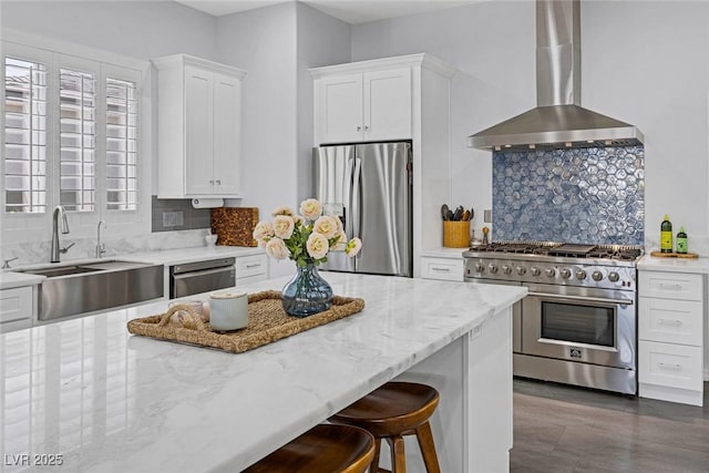 6173 Sabine Ranch Rd, Las Vegas, NV 89131 - kitchen featuring appliances with stainless steel finishes, wall chimney range hood, a sink, backsplash, and light stone countertops