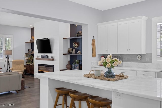 6173 Sabine Ranch Rd, Las Vegas, NV 89131 - kitchen featuring open floor plan, a breakfast bar, white cabinetry, light stone counters, and recessed lighting