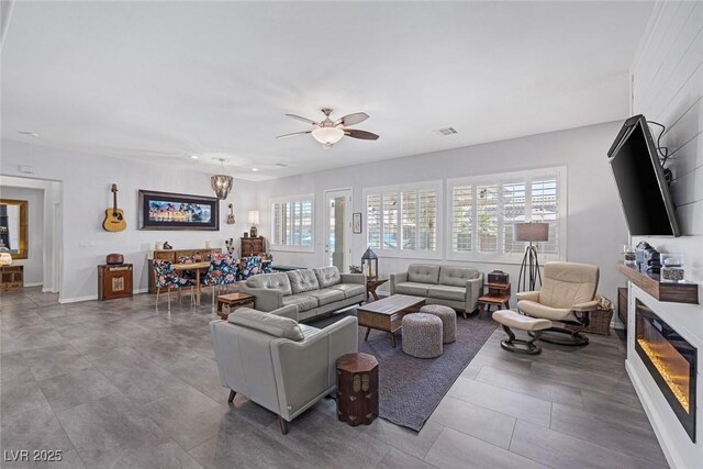 6173 Sabine Ranch Rd, Las Vegas, NV 89131 - living room featuring a fireplace, a ceiling fan, and baseboards