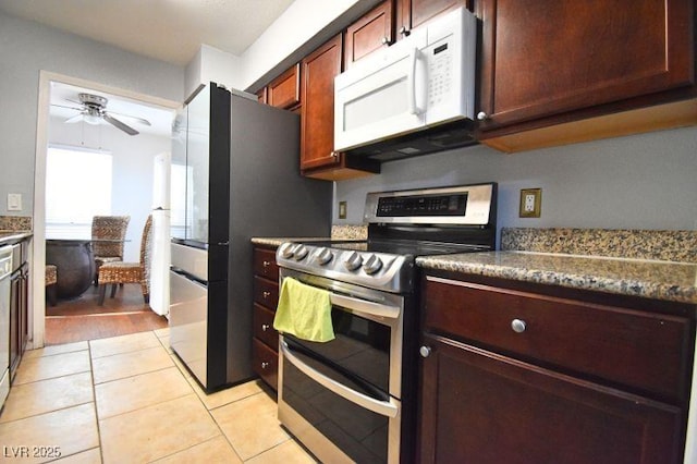 634 Oakmont Ave Unit 1903, Las Vegas, NV 89109 - kitchen with double oven range, white microwave, a ceiling fan, light tile patterned flooring, and dark countertops