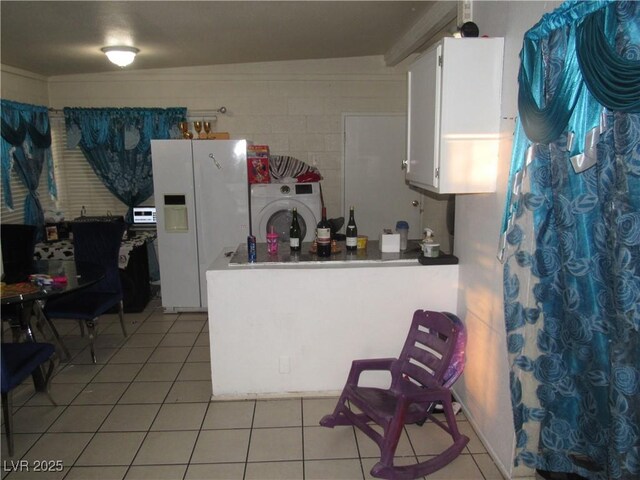 2409 Maroney Ave, Las Vegas, NV 89104 - kitchen with washer / clothes dryer, white refrigerator with ice dispenser, light tile patterned floors, white cabinetry, and a peninsula