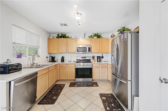 5236 Krista Alethea St, North Las Vegas, NV 89031 - kitchen featuring appliances with stainless steel finishes, a sink, light brown cabinetry, light countertops, and light tile patterned floors