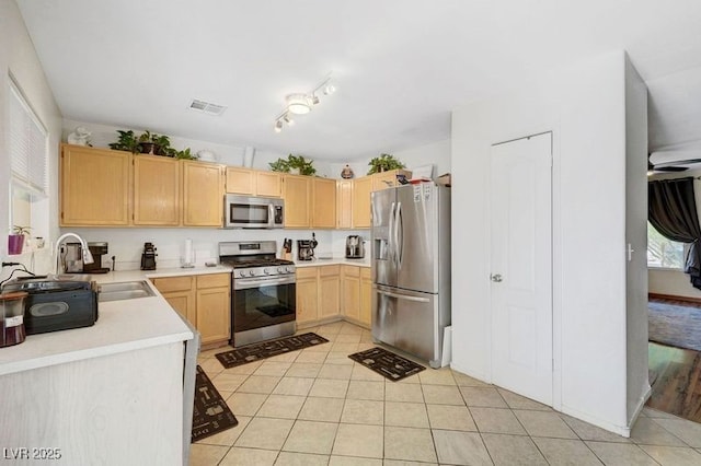 5236 Krista Alethea St, North Las Vegas, NV 89031 - kitchen featuring stainless steel appliances, light brown cabinets, light tile patterned floors, a sink, and light countertops