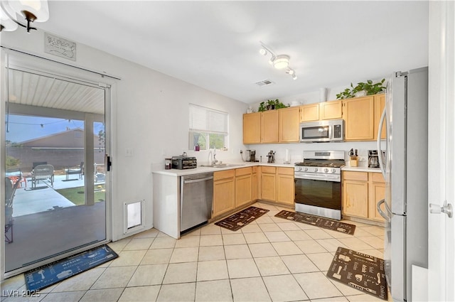 5236 Krista Alethea St, North Las Vegas, NV 89031 - kitchen featuring appliances with stainless steel finishes, light brown cabinets, a sink, light tile patterned floors, and light countertops
