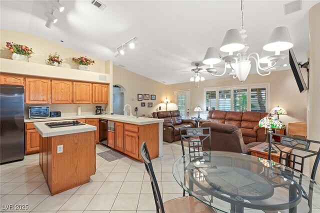 1913 Madagascar Ln, Las Vegas, NV 89117 - kitchen featuring black appliances, vaulted ceiling, track lighting, light countertops, and a peninsula