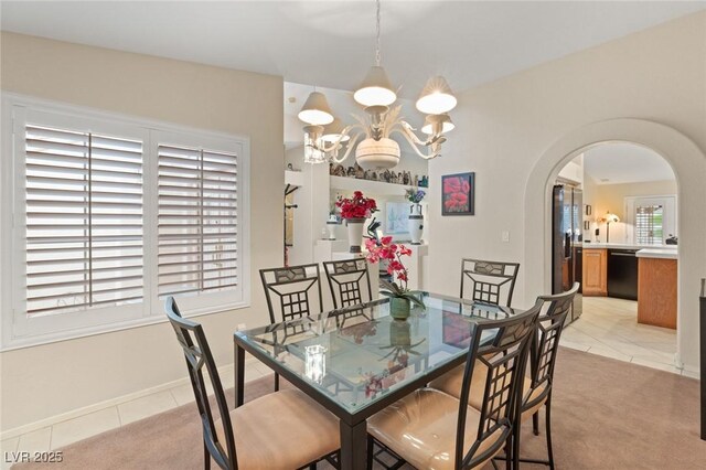 1913 Madagascar Ln, Las Vegas, NV 89117 - dining room featuring a chandelier, arched walkways, light tile patterned flooring, and baseboards