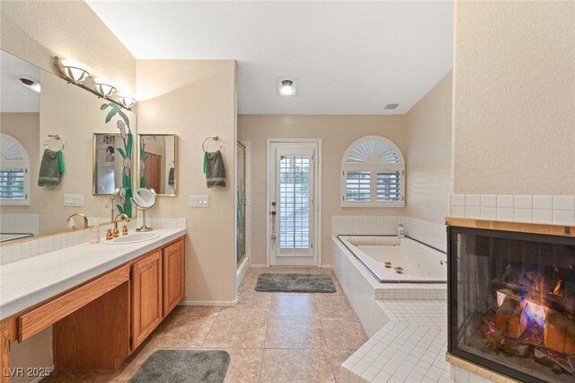 1913 Madagascar Ln, Las Vegas, NV 89117 - full bathroom featuring a jetted tub, a tiled fireplace, vanity, tile patterned flooring, and a shower stall