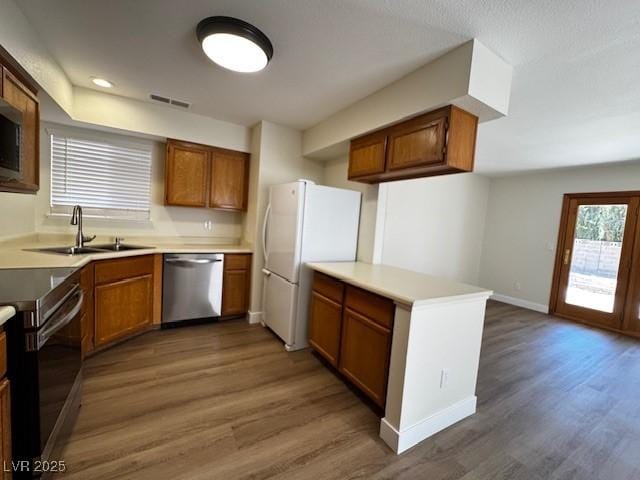 8010 Coffee Tree Ct, Las Vegas, NV 89123 - kitchen featuring appliances with stainless steel finishes, a sink, wood finished floors, brown cabinets, and recessed lighting