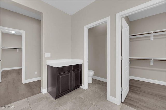 7300 Lavender Rose Ave, Las Vegas, NV 89117 - full bathroom featuring a walk in closet, toilet, and baseboards