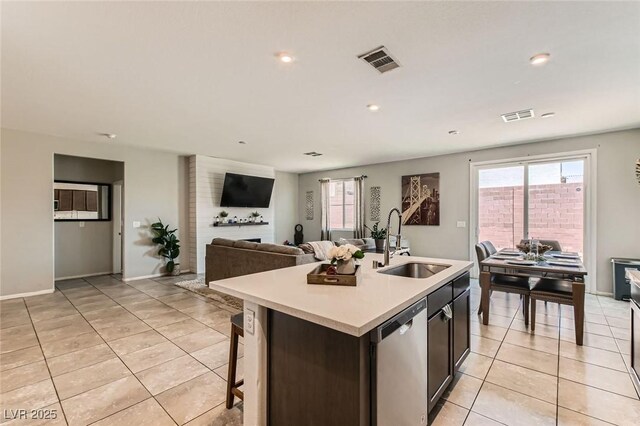 3716 W Colton Ave, North Las Vegas, NV 89032 - kitchen featuring a sink, dishwasher, light tile patterned floors, light countertops, and a kitchen island with sink