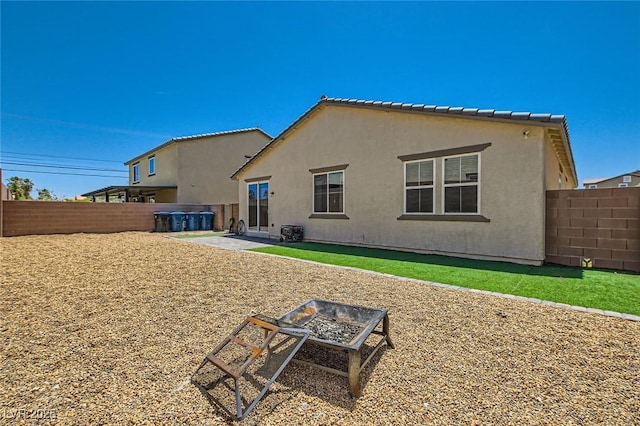 3716 W Colton Ave, North Las Vegas, NV 89032 - rear view of property featuring an outdoor fire pit, a fenced backyard, and stucco siding