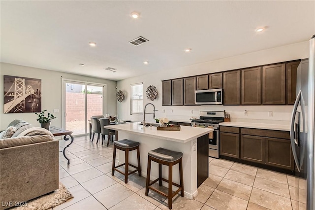 3716 W Colton Ave, North Las Vegas, NV 89032 - kitchen featuring appliances with stainless steel finishes, light countertops, light tile patterned flooring, dark brown cabinetry, and recessed lighting