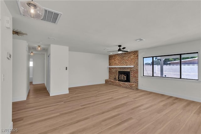 6204 Robin Hood Cir, Las Vegas, NV 89108 - unfurnished living room featuring light wood-style floors, a ceiling fan, baseboards, and a fireplace