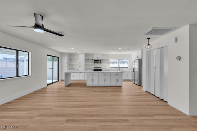6204 Robin Hood Cir, Las Vegas, NV 89108 - kitchen with appliances with stainless steel finishes, white cabinets, light countertops, light wood-style flooring, and ceiling fan