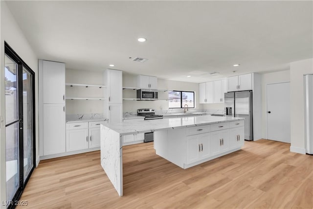 6204 Robin Hood Cir, Las Vegas, NV 89108 - kitchen featuring stainless steel appliances, open shelves, a kitchen island, white cabinets, and recessed lighting