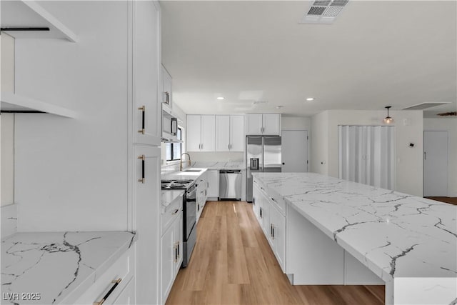 6204 Robin Hood Cir, Las Vegas, NV 89108 - kitchen featuring appliances with stainless steel finishes, a sink, white cabinetry, light wood-style floors, and recessed lighting