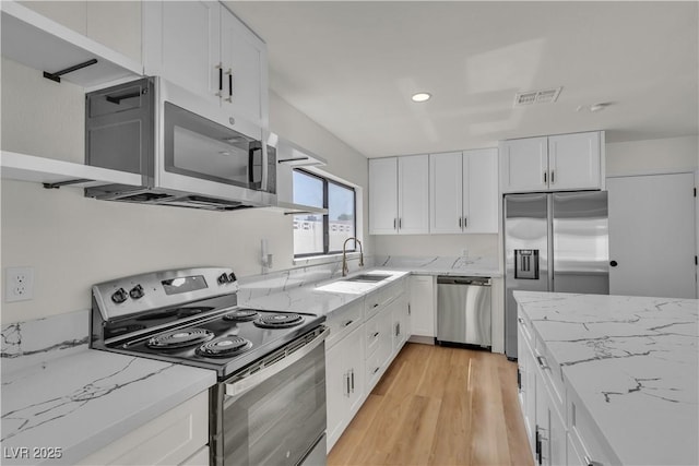 6204 Robin Hood Cir, Las Vegas, NV 89108 - kitchen with appliances with stainless steel finishes, a sink, light wood-type flooring, white cabinetry, and recessed lighting