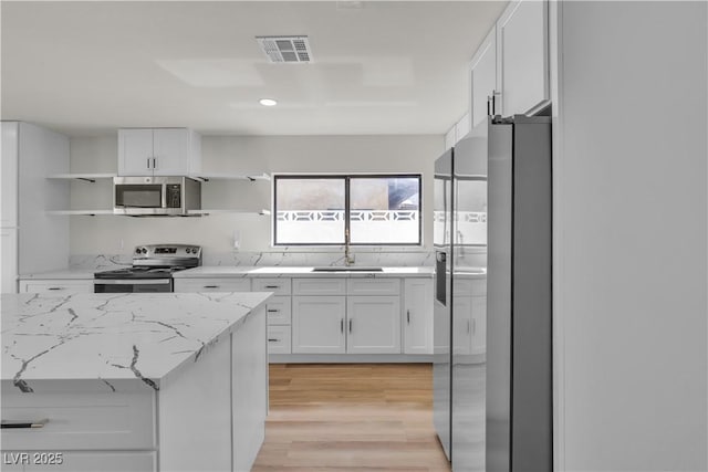 6204 Robin Hood Cir, Las Vegas, NV 89108 - kitchen with open shelves, appliances with stainless steel finishes, a sink, white cabinetry, and recessed lighting