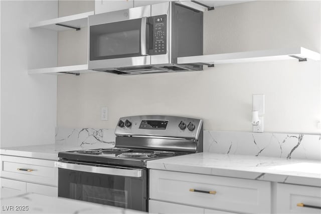 6204 Robin Hood Cir, Las Vegas, NV 89108 - kitchen featuring stainless steel appliances, white cabinets, open shelves, light stone countertops, and decorative backsplash