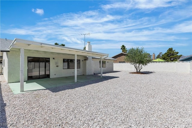 6204 Robin Hood Cir, Las Vegas, NV 89108 - rear view of house with a patio area, a fenced backyard, stucco siding, and a chimney