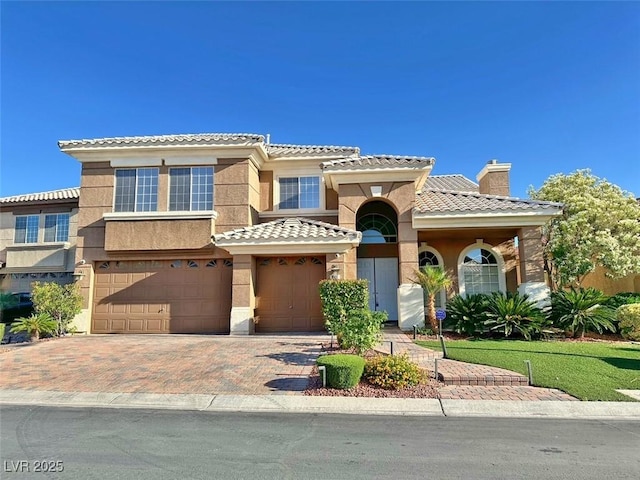 8931 Lansberry Ct, Las Vegas, NV 89147 - view of front of home featuring a tile roof, a chimney, an attached garage, decorative driveway, and stucco siding