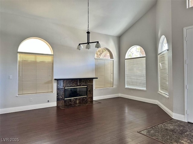 8931 Lansberry Ct, Las Vegas, NV 89147 - unfurnished living room featuring dark wood-type flooring, a fireplace, baseboards, and high vaulted ceiling