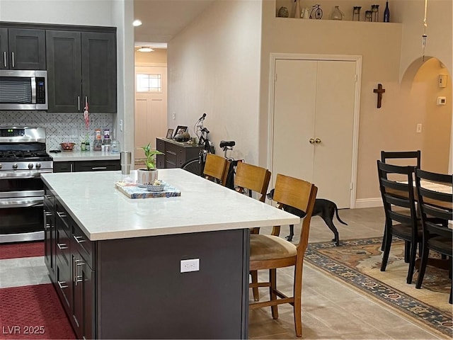 903 Billings St, Henderson, NV 89002 - kitchen with appliances with stainless steel finishes, a breakfast bar area, light countertops, a kitchen island, and recessed lighting