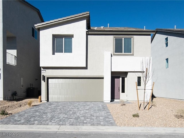 5904 Becklow Gardens Ave, Las Vegas, NV 89141 - view of front facade with an attached garage, stucco siding, decorative driveway, and central AC unit