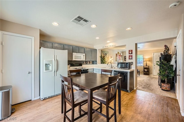 10456 Prairie Schooner Ave, Las Vegas, NV 89129 - kitchen with white appliances, light countertops, a sink, light wood-style floors, and recessed lighting