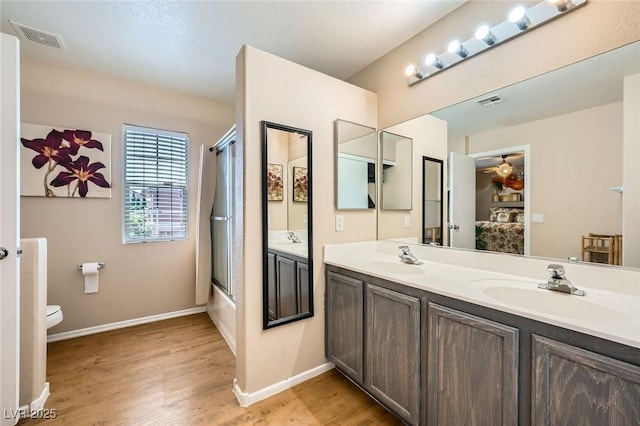 10456 Prairie Schooner Ave, Las Vegas, NV 89129 - bathroom with double vanity, toilet, wood finished floors, and baseboards