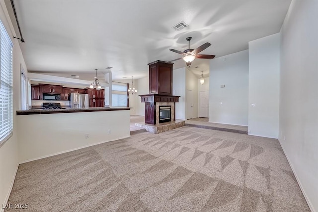 234 Geronimo Ct, Henderson, NV 89074 - unfurnished living room with light colored carpet, a chandelier, ceiling fan, and a large fireplace