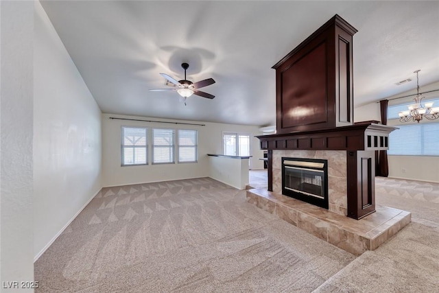 234 Geronimo Ct, Henderson, NV 89074 - unfurnished living room featuring light colored carpet, a tiled fireplace, a ceiling fan, and a chandelier