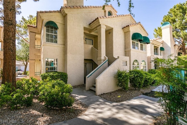 2251 Wigwam Pkwy Unit 824, Henderson, NV 89074 - view of front of property featuring stucco siding, a tiled roof, and a chimney