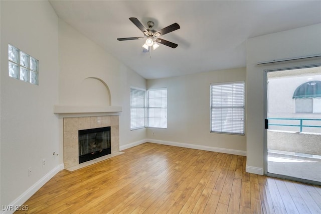 2251 Wigwam Pkwy Unit 824, Henderson, NV 89074 - unfurnished living room with ceiling fan, hardwood / wood-style flooring, vaulted ceiling, a tile fireplace, and baseboards