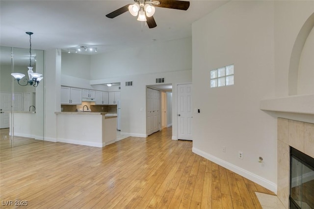 2251 Wigwam Pkwy Unit 824, Henderson, NV 89074 - unfurnished living room with a towering ceiling, a ceiling fan, baseboards, a sink, and light wood finished floors