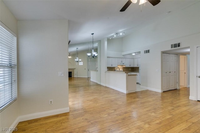 2251 Wigwam Pkwy Unit 824, Henderson, NV 89074 - unfurnished living room featuring a ceiling fan, light wood-type flooring, baseboards, a fireplace, and high vaulted ceiling
