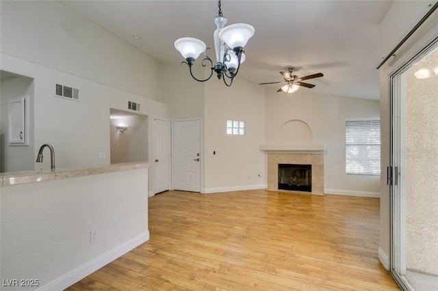 2251 Wigwam Pkwy Unit 824, Henderson, NV 89074 - unfurnished living room with a ceiling fan, a chandelier, light wood-type flooring, a tile fireplace, and baseboards