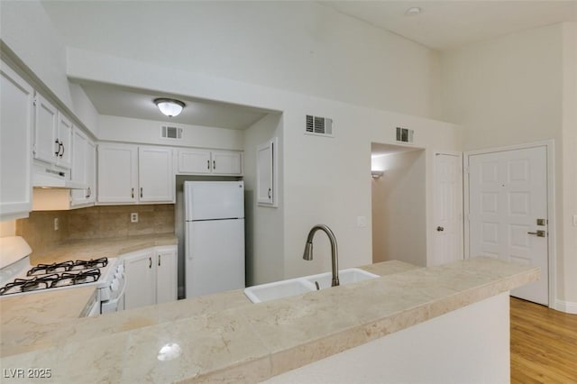 2251 Wigwam Pkwy Unit 824, Henderson, NV 89074 - kitchen featuring white appliances, a sink, under cabinet range hood, light countertops, and light wood-style flooring